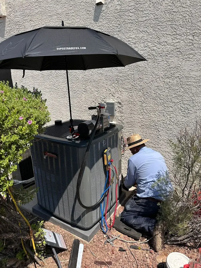 HVAC technician performing outdoor AC maintenance in Whiteland